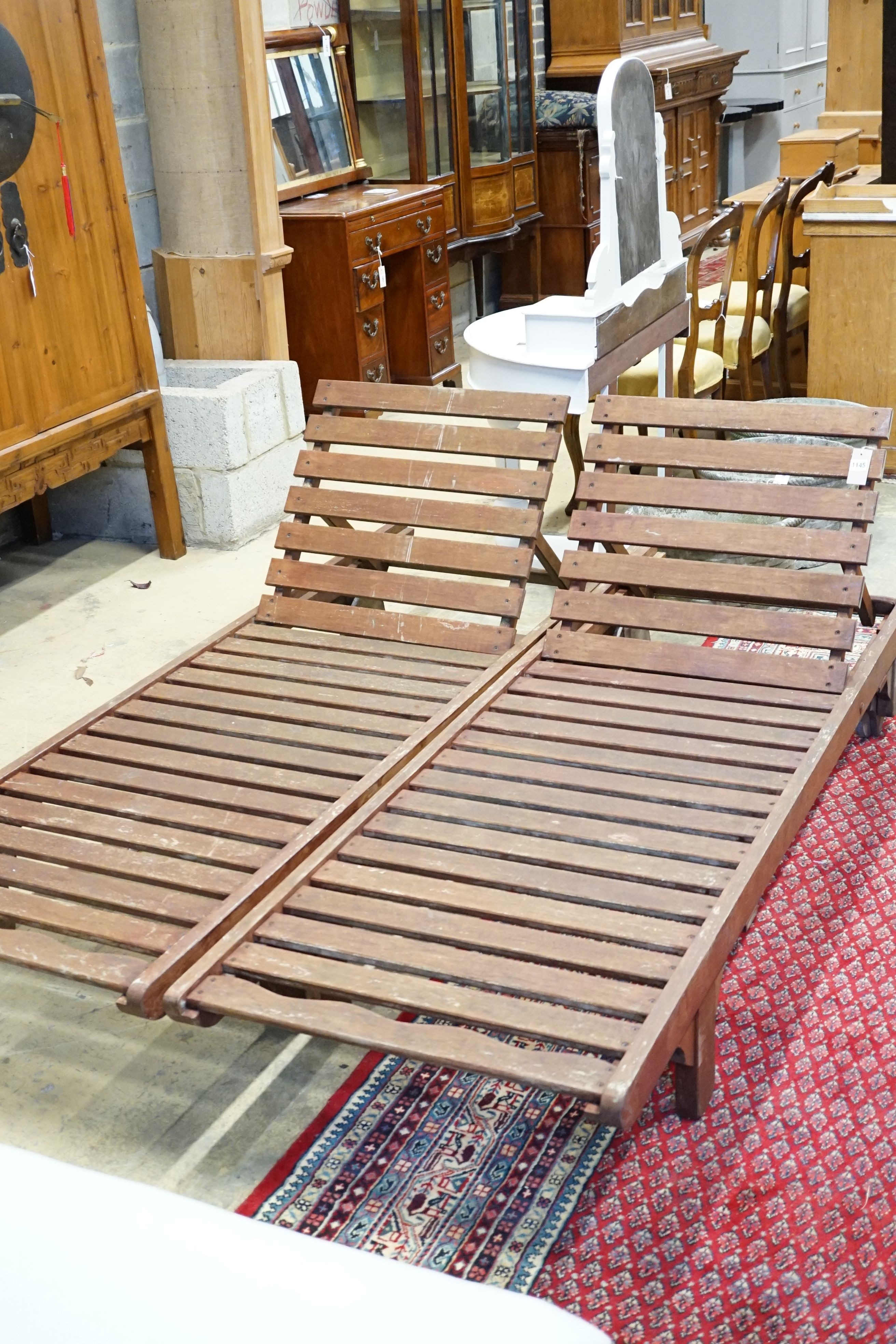 A pair of weathered teak steamer chairs, length 196cm